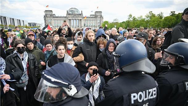 Teilnehmer einer spontanen Unterstützungsversammlung gegen die Räumung des propalästinensischen Protestcamps stehen vor Polizeibeamten.