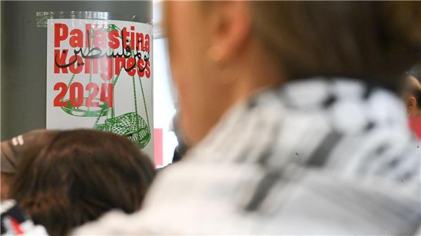 Vorgehen gegen „Palästina-Kongress“ in Berlin kritisiert Teilnehmer sitzen vor Beginn des Palästina-Kongress 2024 im Veranstaltungsraum vor einem Plakat des Kongresses.