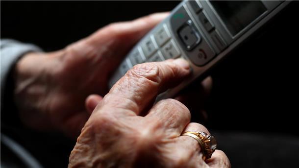 Neue Telefon-Abzocke im Cuxland: Was dahintersteckt und wie Sie sich schützen Eine ältere Frau hält ein schnurloses Festnetztelefon in der Hand.