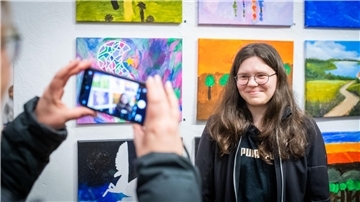 Theresa Schemkes (14) vor ihrem Bild (links), das Erde und Weltall zeigt mit einem Traumfänger, der die schlechten Träume einfangen soll.