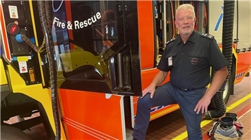 Ein Mann lehnt an einem Feuerwerhrfahrzeug