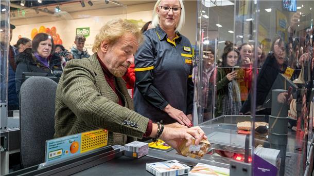 Thomas Gottschalk an einer Supermarkt-Kasse, das Geld aus der Aktion kommt sozialen Zwecken zugute.