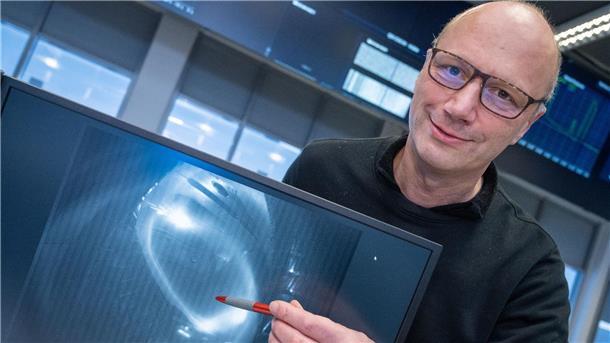 Thomas Klinger, Direktor am Max-Planck-Institut für Plasmaphysik, zeigt ein Bild eines Wasserstoffplasma.