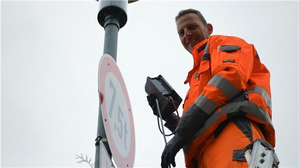 Thorsten Wegner schließt eine Steuerungseinheit an eine Straßenleuchte in der Raiffeisenstraße an. Mit der modernen Technik können die Leuten bedarfsgerecht gedimmt werden.
