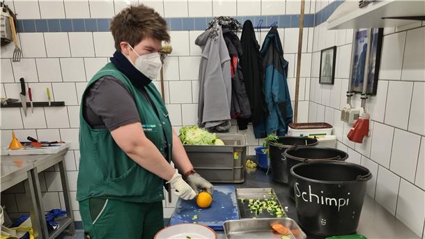 Tierpflegerin Annika Diekmann bereitet im Zoo am Meer das Futter für die Schimpansen vor. Manchmal versteckt sie auch Rosinen in Fahrradreifen, damit die Tiere eine Beschäftigung haben. Schon in der Futterküche arbeitet sie mit FFP2-Maske und Handschuhen.
