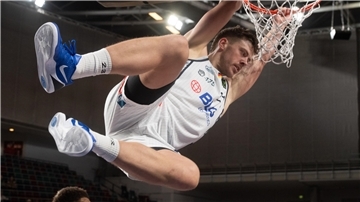 Eisbären feiern den dritten Sieg im dritten Heimspiel Ein Basketballer hängt sich nach einem Dunking an den Korb. Es ist Till Isemann von den Eisbären,