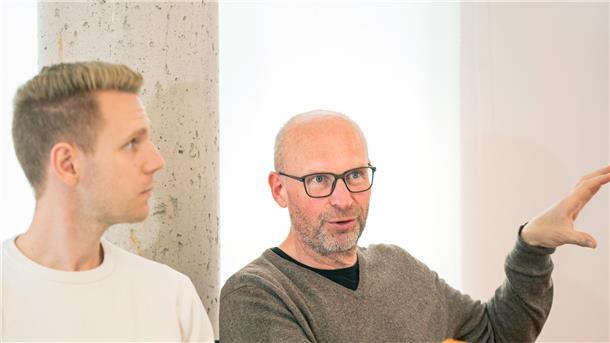 Zwei Männer erklären einen Sachverhalt.