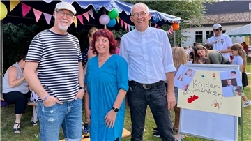 Zwei Männer und eine Frau beim Sommerfest
