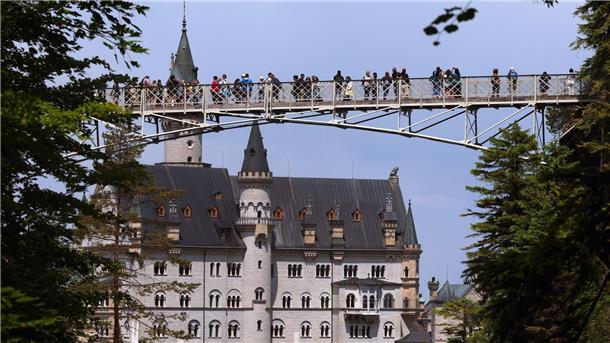 Unesco entscheidet - Ludwig II. baute Hightech-Schlösser Touristen stehen auf der Marienbrücke vor dem Schloss Neuschwanstein. (Archivbild)