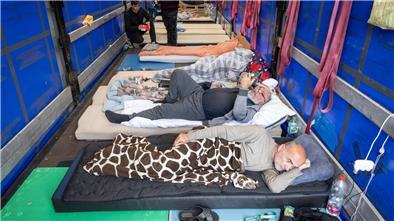 Trucker aus Georgien liegen auf einem Matratzenlager auf der Ladefläche eines Lkw. Sie sind in einen Hungerstreik getreten.