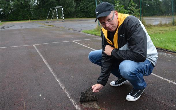 Sportplatz in Tossens wird 2023 saniert TuS-Vorsitzender Renke Hessenius zeigt, dass sich der Kunststoffbelag von der Laufbahn gelöst hat.