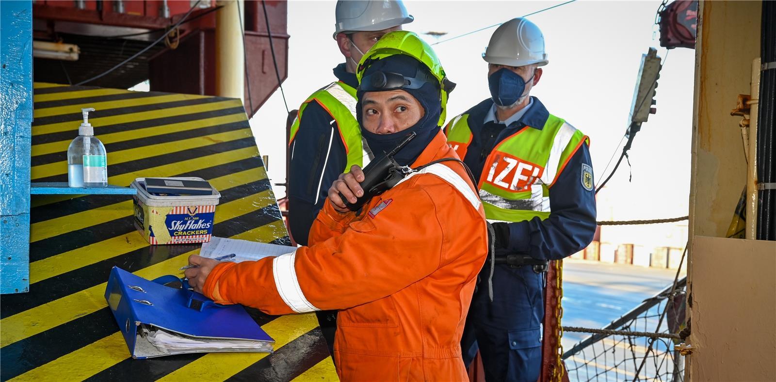 Über das Funkgerät gibt der Watchman an der Gangway einem Crew-Mitglied bescheid...