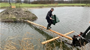Über eine improvisierte Brücke wagte sich Greenkeeper Ralf Hahn auf die neu entstandene Insel.