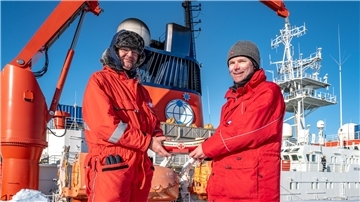 Übergabe in der Antarktis: Gerhard Frank (links), DGzRS-Ehrenamtlicher und Bordtechniker auf dem deutschen Forschungseisbrecher „Polarstern“, überreicht Peter Köhler, Expeditionsleiter der Neumayer-Station, ein Sammelschiffchen der Seenotretter auf Nord- und Ostsee.