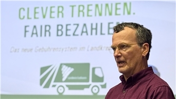 Ein Mann vor einer Abbildung eines Müllfahrzeugs