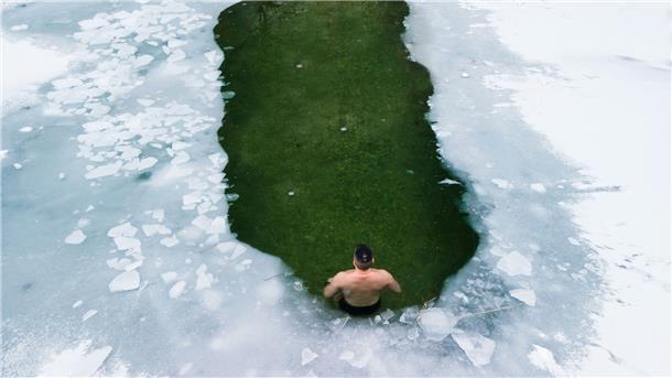 Ein Mann badet im Eiswasser.