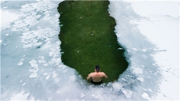 Ein Mann badet im Eiswasser.