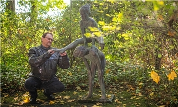 Gartenbauamtsdezernent Ulf Eversberg prüft Schäden einer Skulptur in "Thieles Garten" in Bremerhaven