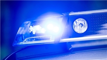 Blaulicht eines Polizeiautos.  Ein schwarzer Kombi erfasste am Freitagmorgen ein 11-jähriges Mädchen auf einem E-Scooter, das auf einer grünen Ampel die Straße überquerte. Der Fahrer, der flüchtete, wird von der Polizei gesucht, während das Kind mit einer Beinverletzung davonkam.  