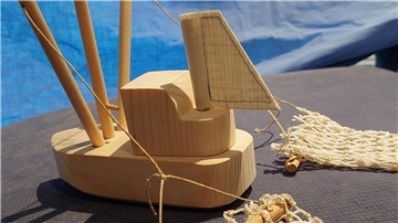  Unter fachkundiger Anleitung bauen die Gäste kleine Holzkutter aus in Handarbeit vorgefertigten Holzbauteilen. Aus den Resten gebrauchter Fischernetze genähte Stützsegel und Mininetze lassen die Kutter noch realistischer aussehen. 