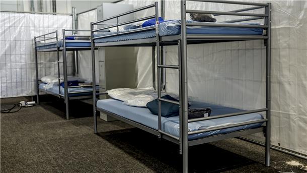Das Foto zeigt eine Flüchtlingsunterkunft in einer Turnhalle. 