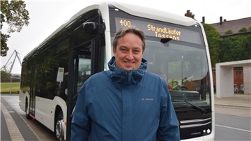 Mann vor Bus