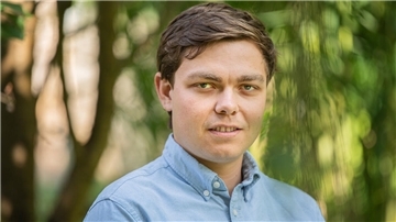 Eike Wittmaier, Veranstalter vom „Sandstedter Sommer“ steht vor einem Banner des Schlager-Festivals.