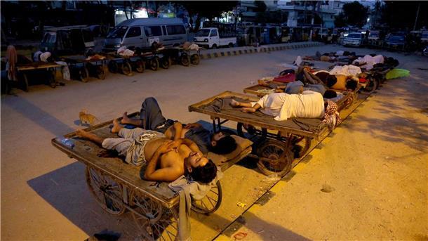 Hitzewellen für Menschen in Pakistan besonders tödlich Verkäufer und Rikscha-Fahrer schlafen an einem heißen Sommermorgen im Freien.