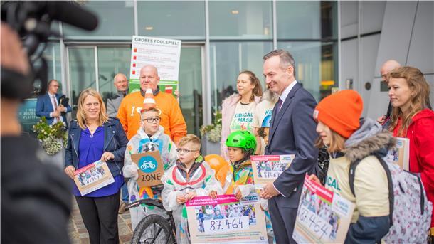 Verkehrssenatorin Maike Schaefer (links) und Bundesverkehrsminister Volker Wissing nehmen die Petition des Aktionsbündnisses „Kidical Mass“ und des ADFC vor dem Atlantic Sail City Hotel für ein neues Straßenverkehrskonzept entgegen. Foto: Hartmann