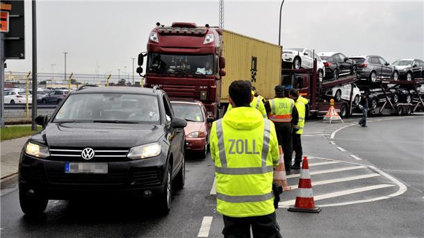 Zollbeamter vor Fahrzeugen. 
