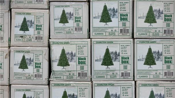 Verpackte Weihnachtsbäume aus Kunststoff (PVC) in einem Baumarkt.