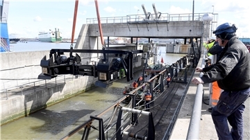 Verschwindet wieder in der Tiefe: Ein Kran setzt den ersten der beiden Unterwagen in die Torkammer der Kaiserschleuse.