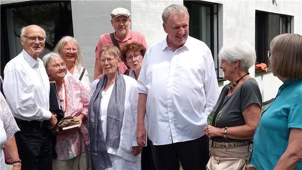 Eine Gruppen von Menschen vor einem Gebäude. Viele Weggefährten waren gekommen, um sich von Pfarrer Karl Jasbinschek (3. von rechts) zu verabschieden.
