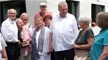 Eine Gruppen von Menschen vor einem Gebäude. Viele Weggefährten waren gekommen, um sich von Pfarrer Karl Jasbinschek (3. von rechts) zu verabschieden.