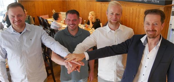 Traditionsunternehmen Thieling aus Stadland hat jetzt neue Eigner Vier Männer stehen nebeneinander und legen je eine Hand auf die Hände der anderen.