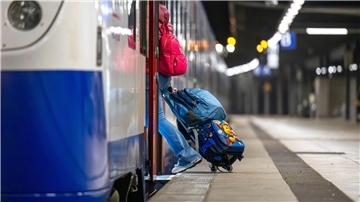Eine Frau mit Koffern steigt in einen Regiozug der Nordwestbahn. 