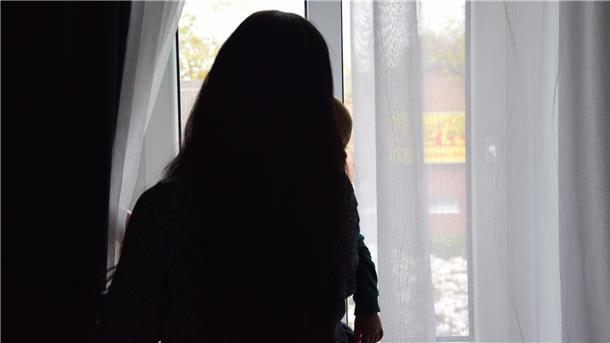 Wie eine Ukrainerin in der Wesermarsch eine neue Heimat gefunden hat Eine Frau steht am Fenster und sieht mit ihrem Kind nach draußen.