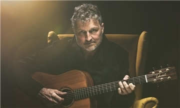Volker Rechin spielt in Selsingen in seinem gelben Sessel solo an der Gitarre unter anderem Songs seiner Band 3 Miles To Essex.