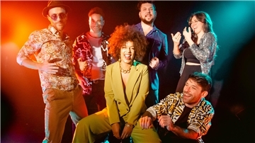 Eine Gruppe lachender Musiker. 
