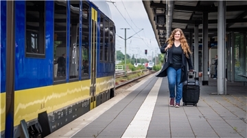 Volontärin Luise Langen steht mit gepackten Koffern am Bahnsteig in Bremerhaven, bereit für den Last-Minute-Urlaub.