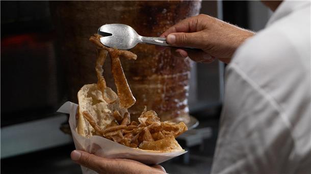 Döner-Streik in Großfabrik: Bleiben jetzt die Spieße stehen? Vom Spieß ins Brot: Ein Mann bereitet einen Döner zu. (Archivbild)