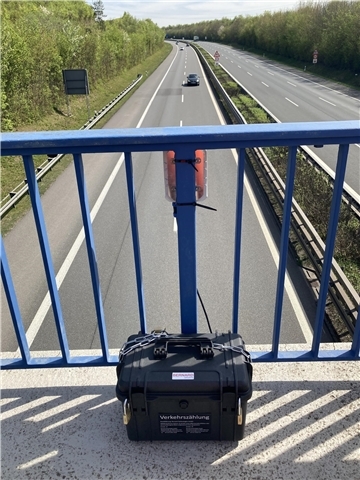 ein Gerät zur Verkehrszählung ist auf einer Brücke über einer Autobahn angebracht