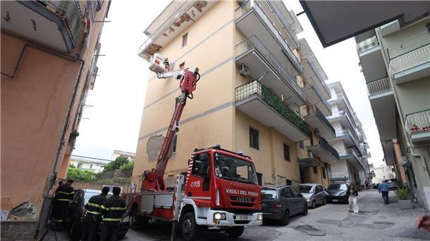 Erdbeben in Neapel: Häuser und Gefängnis evakuiert Von einem Hubwagen aus inspiziert ein Feuerwehrmann Schäden an einem Gebäude.