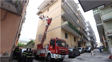 Von einem Hubwagen aus inspiziert ein Feuerwehrmann Schäden an einem Gebäude.