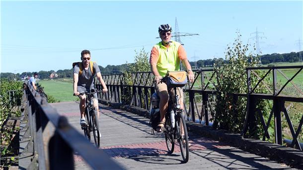 „Sieben-Seen-Route“: Sechs Seen und ein Feuchtgebiet Von links: NZ-Volontär Gregor Teichmann (34) und ADFC-Mitglied Knut Müller (70) beim Überqueren der Schiffdorfer Stauschleuse. Das seit 1985 unter Denkmalschutz stehende Sperrwerk ist eine der Sehenswürdigkeiten, die direkt an der Strecke der „Sieben-Seen-Route“ liegen.