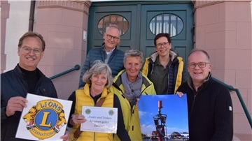 Gruppe mit Plakaten in der Hand vor Hauseingang