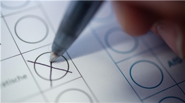 Detail: Ein Kugelschreiber macht ein Kreuz auf einem Stimmzettel für politische Wahlen.