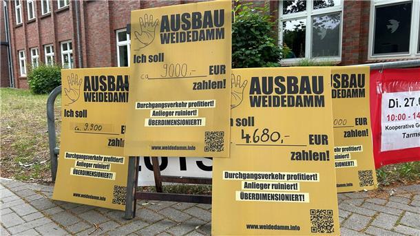 Warum der Streit um den Weidedamm-Ausbau in Tarmstedt nicht vorbei ist Vor der Ratssitzung stellen einige Anlieger der Straße Weidedamm Plakate auf, die sonst vor ihren Grundstücken stehen und anzeigen, wie teuer der Straßenausbau für sie wird.