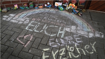 Vor einer Kindertagesstätte ist der Schriftzug „Liebe Kinder, wir vermissen Euch, Eure Erzieher“ auf den Boden geschrieben. Eltern stellen die geschlossenen Kitas vor noch größere Probleme.