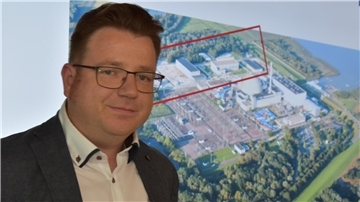 Vor einer Luftbild-Projektion des Kraftwerksgeländes mit dem rot markierten Bereich der Zwischenlager: stellvertretender Zwischenlager-Leiter Stephan Thode.